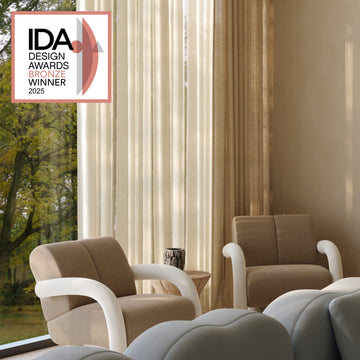 Modern living room with brown and beige furniture, featuring IDA Design Awards Bronze Winner 2025 badge.
