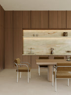 Modern kitchen with wooden cabinets, marble backsplash, and dining table.