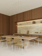 Modern kitchen with wooden cabinets, marble backsplash, and dining table.