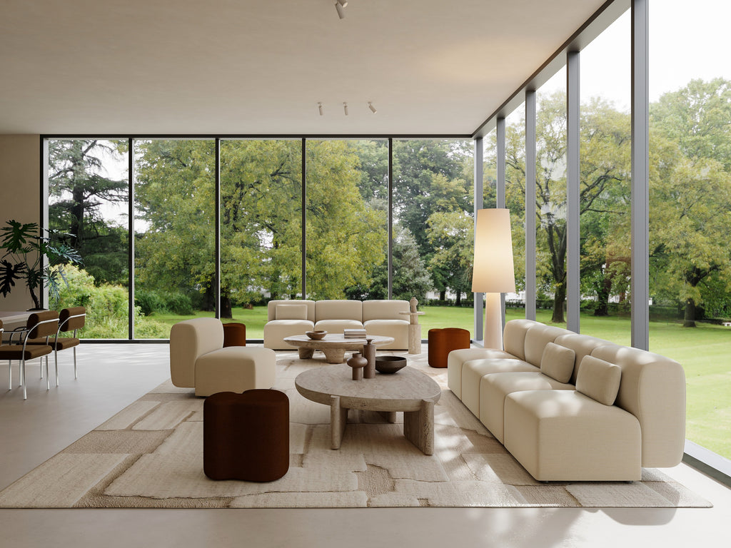 Modern living room with large windows, beige sofa, and decorative items.