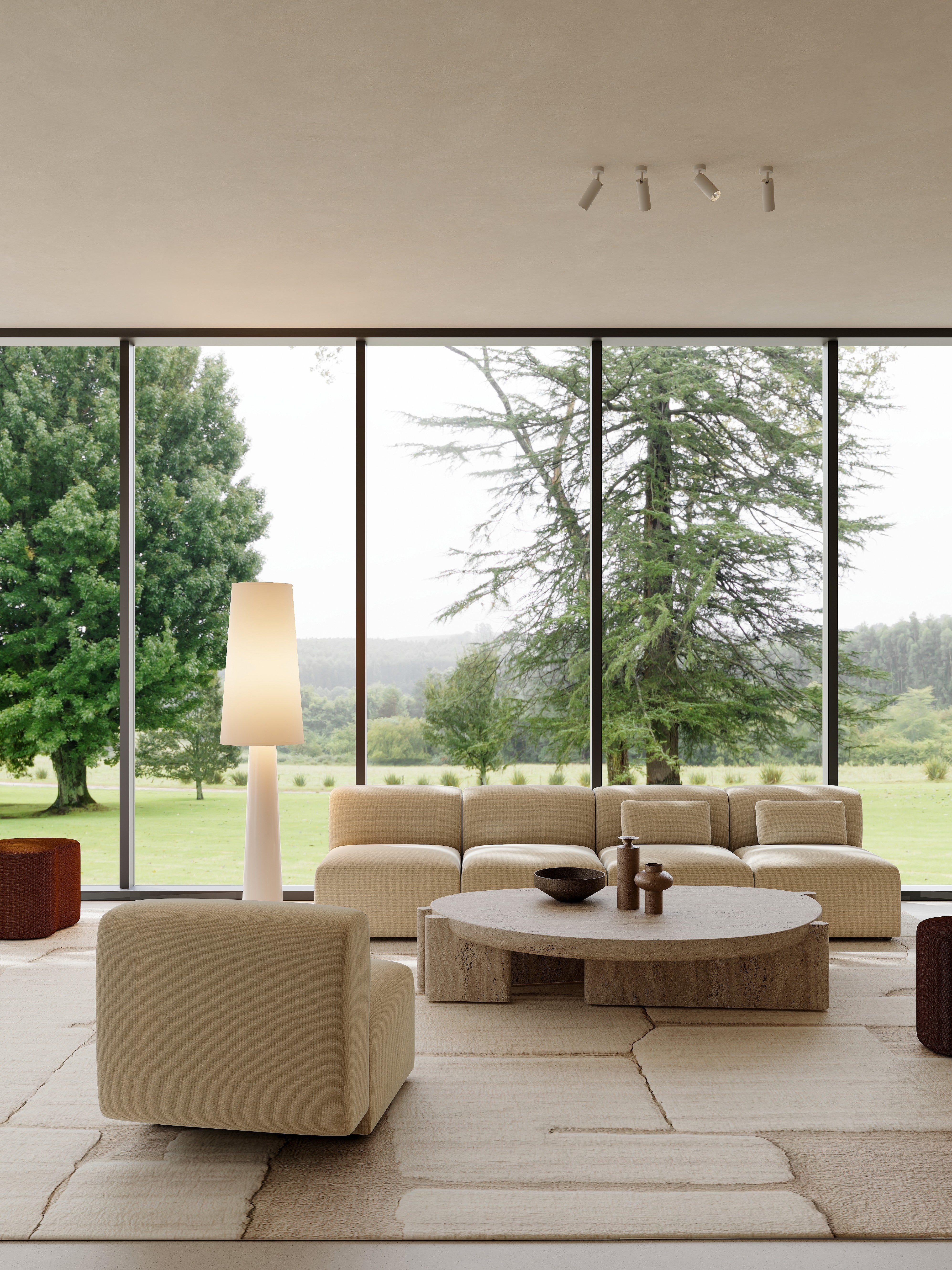 Modern living room with large windows, beige sofa, and decorative items.