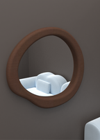 An irregularly shaped circular mirror with a brown frame, hanging on a wall above a light-colored sofa.